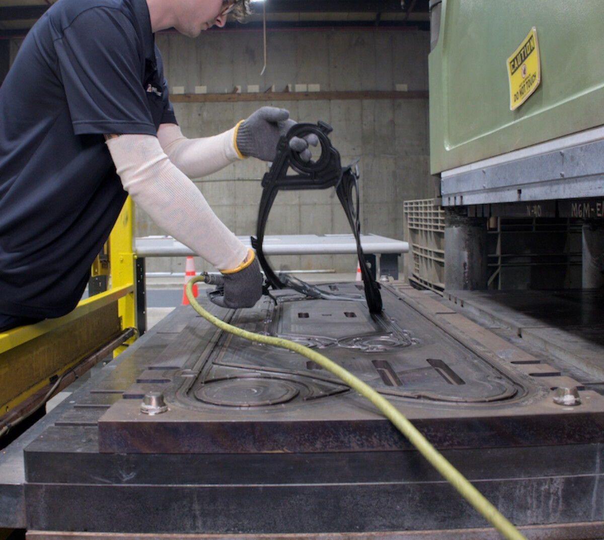 PHE Gaskets employee peeling a new heat exchanger gasket from a steel template